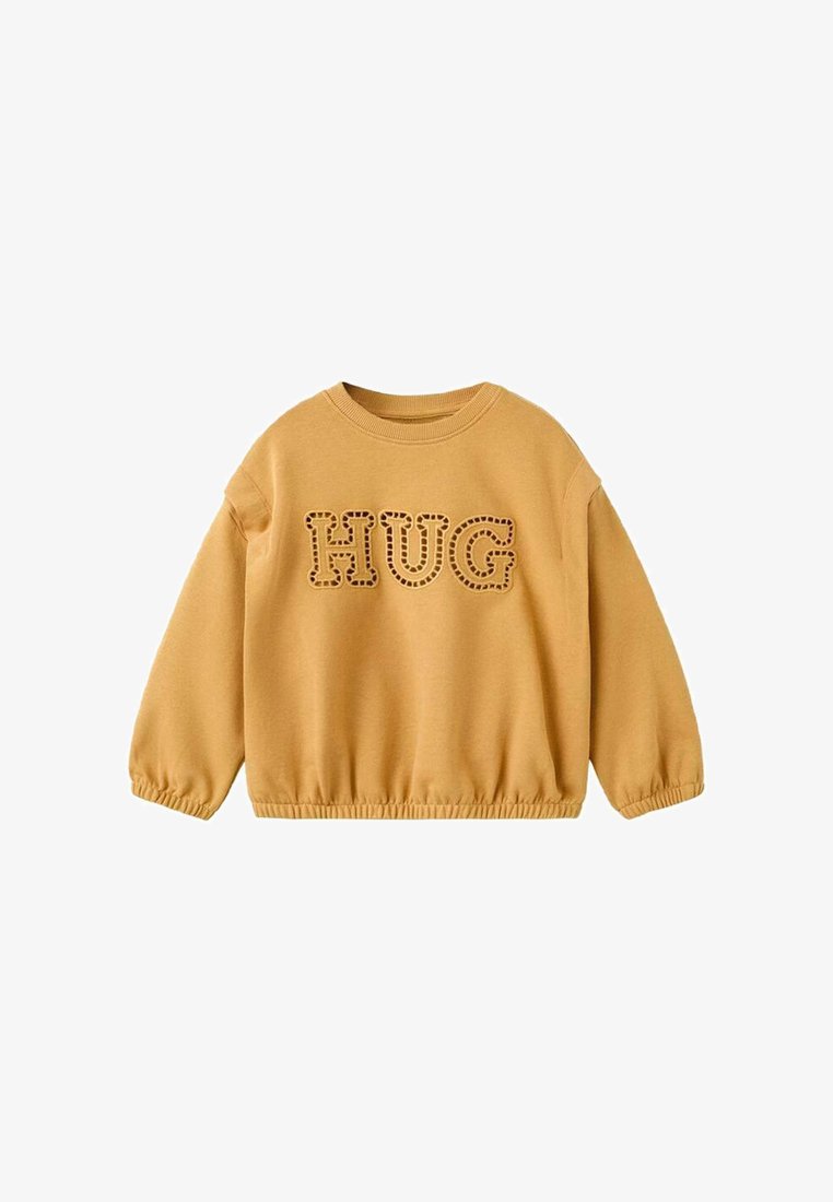 Sweat-shirt à manches longues jaune moutarde avec poignets et ourlet élastiques, arborant le mot "HUG" en grandes lettres cousues sur la poitrine.