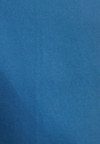 Heldere blauwe stof met een gladde, subtiele textuur en een uniform patroon, geschikt voor verschillende toepassingen zoals kleding of meubels.