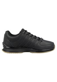 Black athletic shoes with a smooth leather upper, textured accents, six lacing loops, and a cushioned rubber sole. Minimal design.