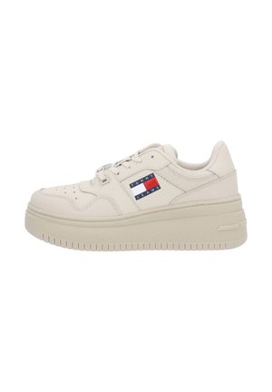 Beżowy niski sneaker z grubą podeszwą, perforowanym noskiem, sznurowanym przodem i naszywką z logo Tommy Jeans po boku.