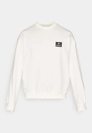 Felpa bianca con scollo rotondo e maniche lunghe, dotata di un piccolo etichetta nera con il logo "snow peak" nella parte sinistra del petto.