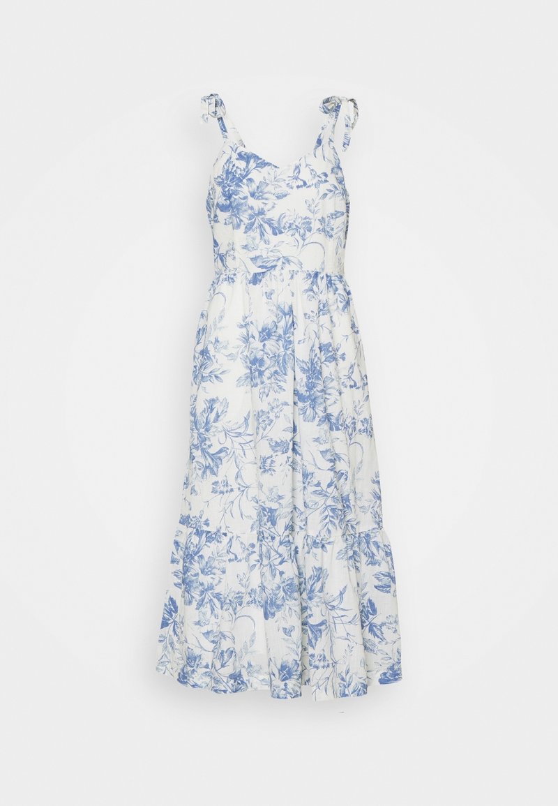 Robe midi blanche sans manches avec imprimé floral bleu et bretelles nouées aux épaules.