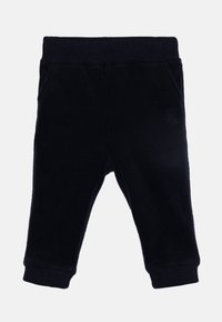 Pantalones joggers de forro polar azul marino con cintura y puños acanalados, que cuentan con bolsillos laterales y un logo en relieve en el muslo izquierdo. Textura suave.