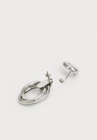 Pendientes de plata con un diseño retorcido y un respaldo plano. Incluyen un pendiente de botón redondo. Textura metálica suave.