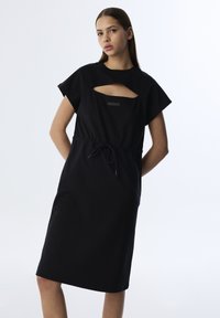 Schwarzes Kleid mit kurzen, weiten Ärmeln und einem Ausschnitt an der Brust. Verfügt über einen verstellbaren Kordelzug in der Taille und hat eine glatte Textur.