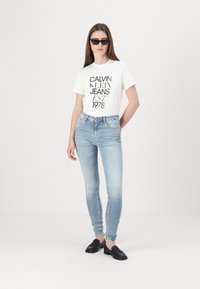 Tommy Jeans NORA - Kitsa lõikega teksad - denim light