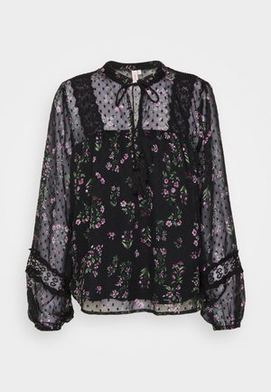 Sort blomsterbluse med gennemsigtig stof, prydet med grønne og lilla blomster, blonder detaljer, en snøre hals og lange, puffede ærmer.