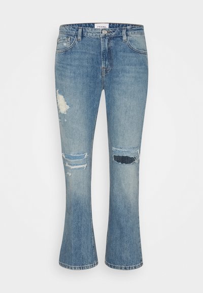 Calças de ganga largas em azul claro com detalhes desgastados, apresentando rasgões nos joelhos e uma lavagem desbotada para um aspeto texturizado.