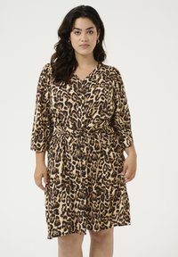 Robe en imprimé léopard beige et marron, avec un col en V, des boutons sur le devant, des manches trois-quarts et un détail de taille nouée.