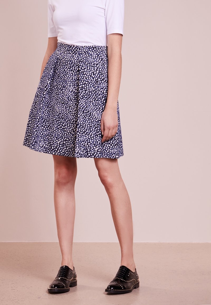Gonna blu navy con motivo a pois bianchi, design plissettato e vita aderente. Abbinala a scarpe oxford nere con borchie.
