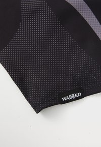Černá tkanina s tečkovaným vzorem, s rohovými designovými prvky. V dolním rohu je viditelný bílý štítek s nápisem "WASTED".