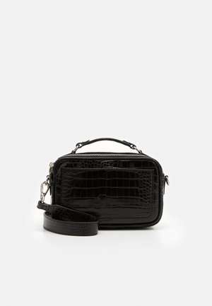 Petit sac bandoulière rectangulaire noir à texture crocodile, avec sangle détachable, poignée supérieure et poche avant zippée, sur un fond clair uni.