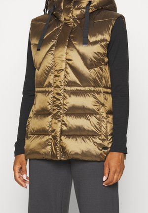 Doudoune dorée sans manches avec capuche, dotée d'un design matelassé, de cordons de serrage noirs contrastants et de poches latérales, superposée à une chemise noire à manches longues.