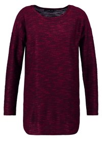 Bordeaux långärmad tröja i strukturstickad tyg med rundad halsringning och en avslappnad passform. Kantarna är något rundade på sidorna.