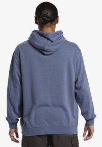 Hooded sweatshirt in light blue, featuring a relaxed fit, ribbed cuffs, and hem. Soft fabric texture with a large back hood.