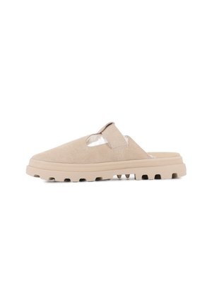 Chaussure slip-on en suède beige avec un design découpé, une semelle texturée et un coussin à l'intérieur. Elle dispose d'une sangle pour un maintien sécurisé.
