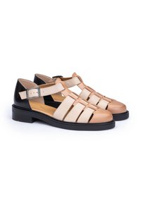 Sandalias de cuero con bloques de color beige y negro, diseño de punta abierta, correa ajustable con hebilla y suela negra resistente.