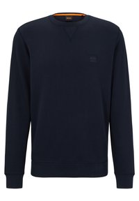 Marinblå crewneck sweatshirt, mjukt tyg, ribbade ärmslut och nederkant, med en diskret logotyp på bröstet och en orange accent inuti kragen.