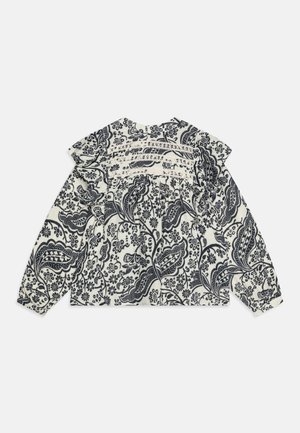 Langermet topp i krem med mørk blå blomster paisley-mønster, med volangskuldre og en samlet bakside med blonder.