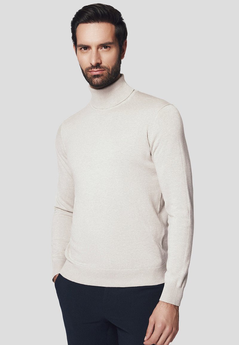 Beżowy sweter z golfem wykonany z miękkiego materiału dzianinowego, z długimi rękawami i prążkowanym wykończeniem, o prostym, minimalistycznym designie.