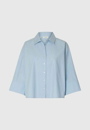 Lyseblå skjorte med knapper, brede 3/4-ærmer og spids krave på ensfarvet baggrund.