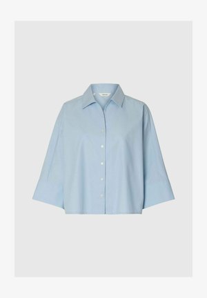 Lyseblå skjorte med knapper, brede 3/4-ærmer og spids krave på ensfarvet baggrund.