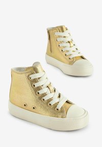 Złote sneakersy z wysoką cholewką o metalicznym wykończeniu, białymi sznurówkami, wzmocnionym czubkiem oraz teksturowanymi bokami. Posiadają boczny zamek błyskawiczny dla łatwego zakładania.