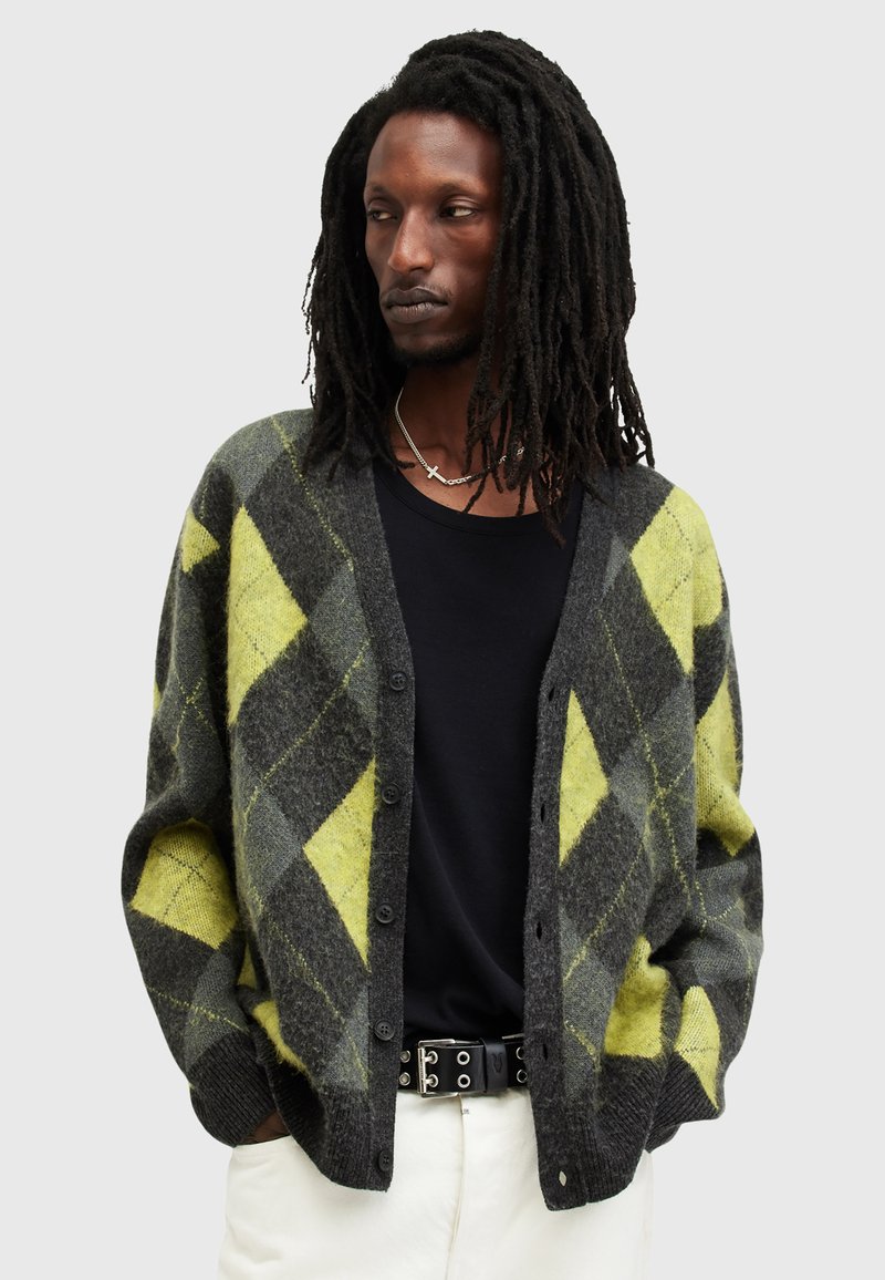 Cardigan con un motivo geometrico a diamante in nero e verde lime, realizzato in tessuto testurizzato con chiusura a bottoni e polsini a costine.