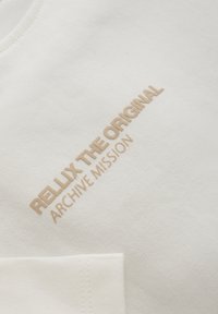 Witte katoenen sweatshirt met beige geborduurde tekst "RELLIX THE ORIGINAL ARCHIVE MISSION." Soepele textuur met een ronde hals.