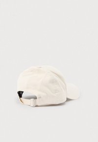 Krém színű kordbársony sapka ívelt karimával, állítható hátsó pánttal és varrott felső panellel a részletekért.