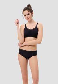 Schwarzes Bralette und passendes Höschen-Set mit Spitzenbesatz, das ein gerafftes Design und weichen Stoff aufweist. Die Spitze verleiht dem schlichten Stil eine besondere Note.