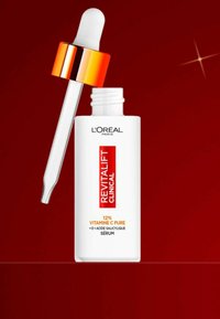 Flacon blanc avec une étiquette rouge et orange, capuchon compte-gouttes avec un accent orange. Contient le sérum pur de vitamine C 12 % Revitalift Clinical.
