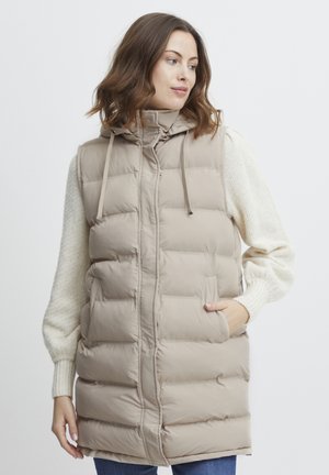 Beige puffer vest with a hood, featuring a quilted design, side pockets, and contrasting textured sleeves in a cream color.