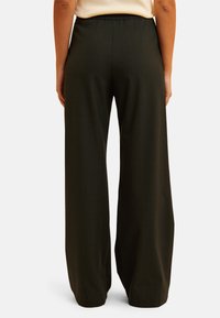 Wide-leg pants in dark green with a subtle check pattern. Made from a smooth fabric, featuring an elastic waistband for comfort.