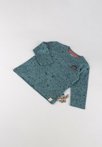 Tannengrünes Langarmshirt mit geometrischem schwarzem Muster, ausgestattet mit gerippten Bündchen und einem kleinen Logo-Patch. Enthält ein Stofffüchse-Spielzeug.