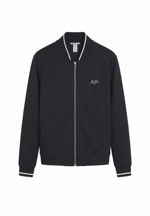 Schwarze Zip-Up-Jacke mit weißem Besatz an Kragen und Bündchen, Vorderentaschen und einem kleinen "AM"-Logo auf der linken Brust.