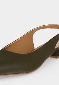 Χαμηλά τακούνια σε σχήμα slingback ελιάς με μυτερή μύτη και καφέ εσωτερική επένδυση σε λευκό φόντο.