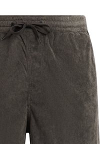 Pantaloni di velluto a coste grigio scuro con vita elastica e coulisse nera annodata a fiocco sul davanti.