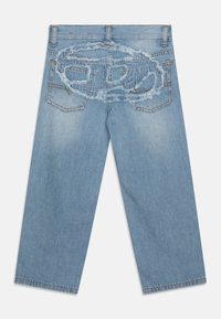 Helle blaue Denim-Jeans mit lockerer Passform, die auf der Rückseite über fransige Details in ovaler Form verfügen. Fünf Taschen und Standardnähte.