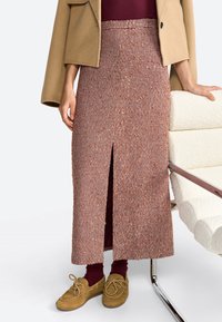 Ruda ir kreminė houndstooth maksi sijonas su priekinio skilimo detalėmis, derinamas su rudais batais ir bordo kojinėmis, dėvimas su kreminės spalvos striuke.