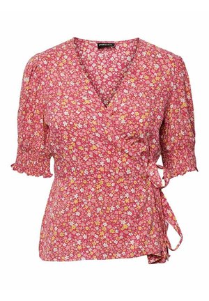 Blouse portefeuille florale rose avec manches courtes bouffantes et poignets à volants, nouée sur le côté pour une taille ajustée.