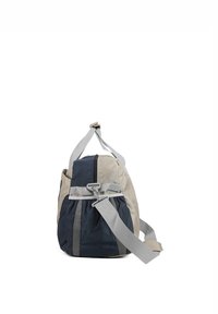 Sac de sport avec un design beige et marine, featuring un tissu texturé, une bandoulière grise réglable, et une poche latérale en mesh.