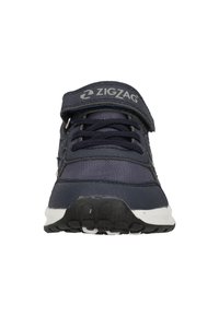 Chaussure de sport marine avec un dessus en maille et synthétique, fermeture Velcro, semelle blanche, semelle texturée, et logo en zigzag subtil sur la sangle.