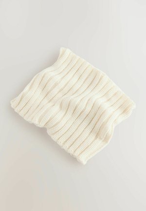 Cagoule en tricot crème avec une texture côtelée verticale, en matériau doux et de forme flexible, pliée et posée sur une surface claire.