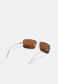 Braune rechteckige Sonnenbrille mit einem dünnen silbernen Metallrahmen, der gekrümmte Tempelarme und klare, verstellbare Nasenpolster aufweist.
