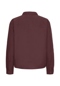 Camicetta bordeaux a maniche lunghe, con colletto e una texture liscia, caratterizzata da polsini con bottoni e un orlo dritto, con un singolo dettaglio di yoke sul retro.