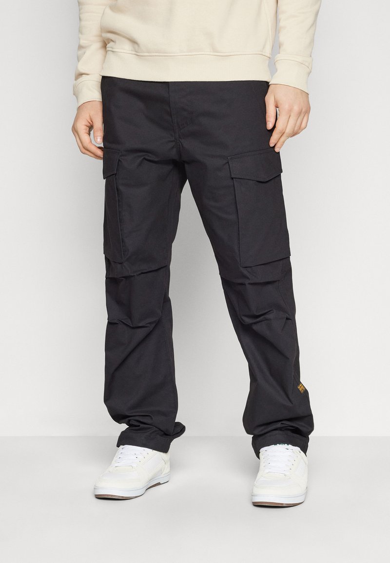 Schwarze Cargo-Hosen mit mehreren Taschen, einem lockeren Schnitt und einem leichten Stoff. Akzente sind ein kleines Logo auf der Tasche und schmal zulaufende Bündchen.