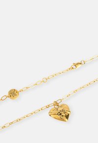 Golden heart-shaped pendant necklace featuring a floral design, with a textured finish and a lobster clasp closure on a linked chain.