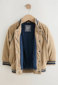 Jasny brązowy jacket z korduroy z granatowym polarem wewnątrz, zatrzaskami, żebrowanymi mankietami oraz paskami na kołnierzu i mankietach.