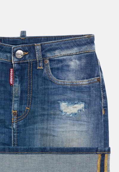Μπλε denim μίνι φούστα με μπροστινή τσέπη, κλείσιμο με κουμπί, ξεθωριασμένο πλύσιμο, λεπτομέρειες φθοράς και μικρή κόκκινη υφασμάτινη ετικέτα μάρκας.